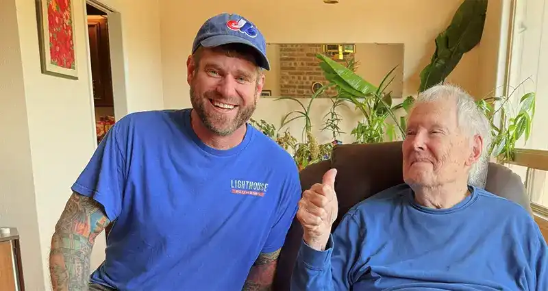 Lighthouse Plumbing team member with satisfied customer